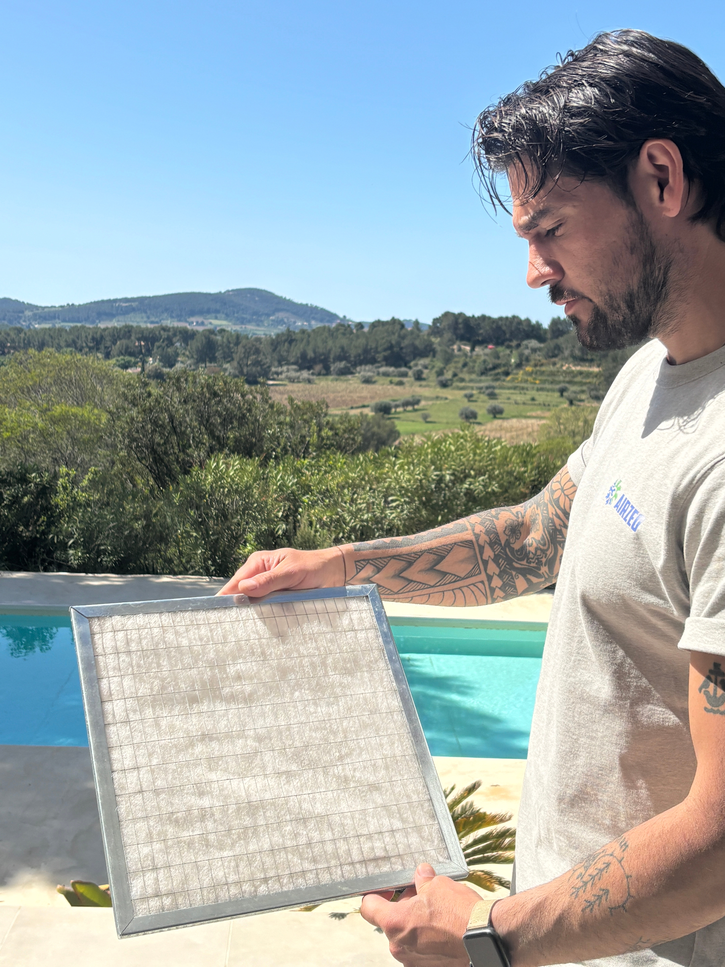 Technicien Airzeo inspectant un filtre de climatisation gainable encrassé lors d'un entretien dans le Var (PACA)